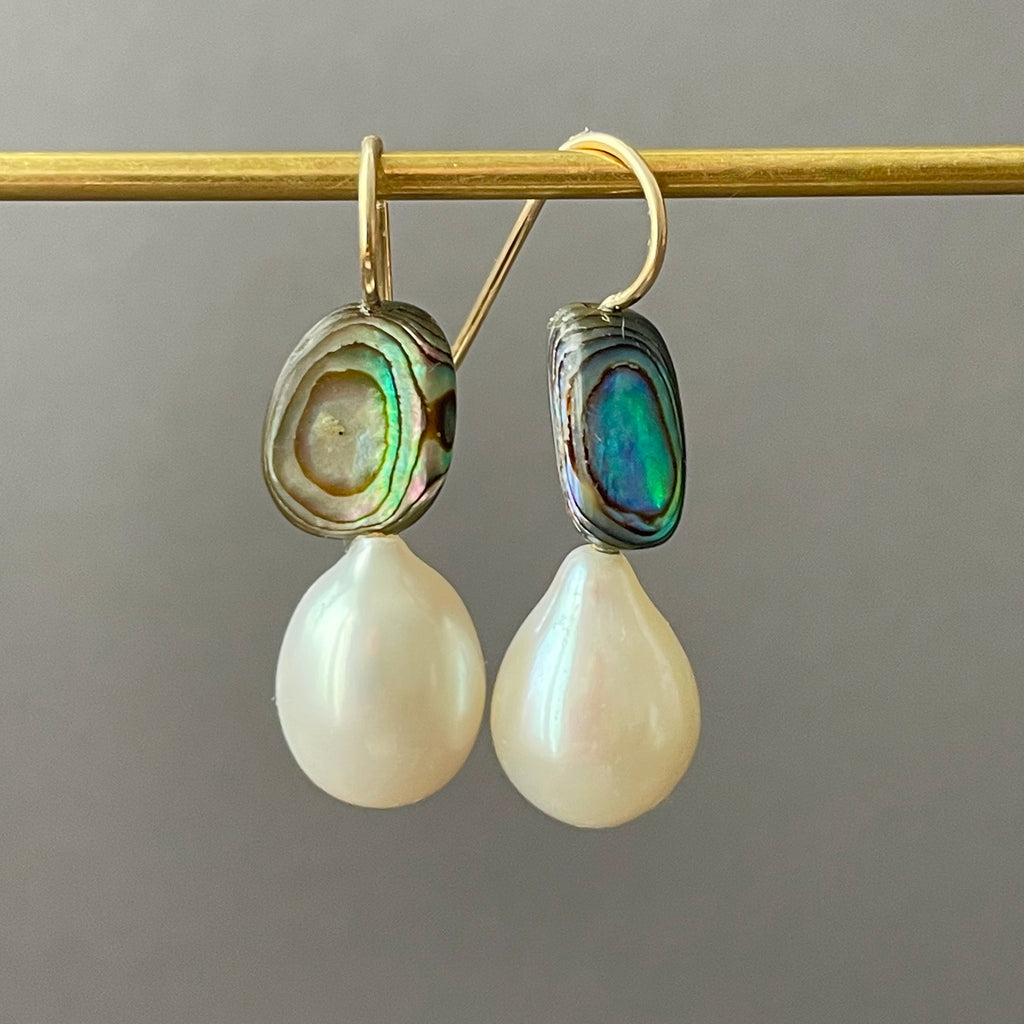 green eyes and white drop pearl earrings