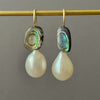 green eyes and white drop pearl earrings