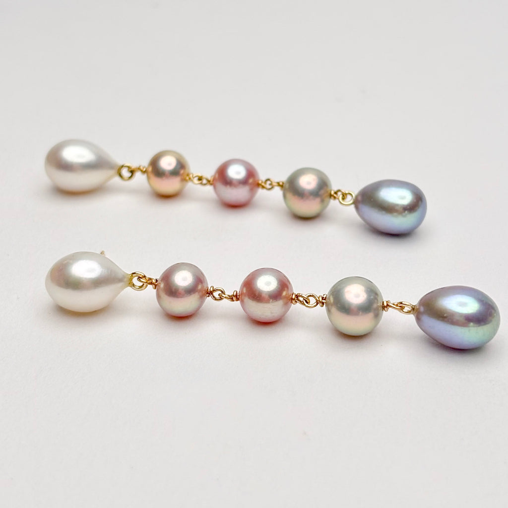 Five tier ombre pearl earrings with gold chain on a light gray background