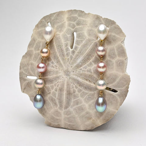Five tier ombre pearl earrings on a sand dollar with a white background