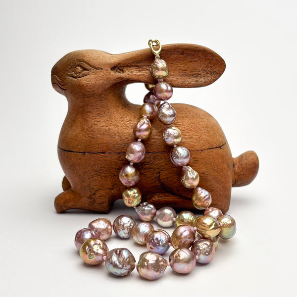 Wooden rabbit-shaped box with a Japan Kasumi pearl necklace draped over it on a white background