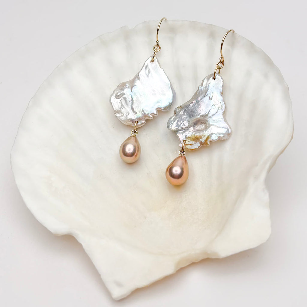 Pearl and gold drop earrings on a white shell  by kojima pearl